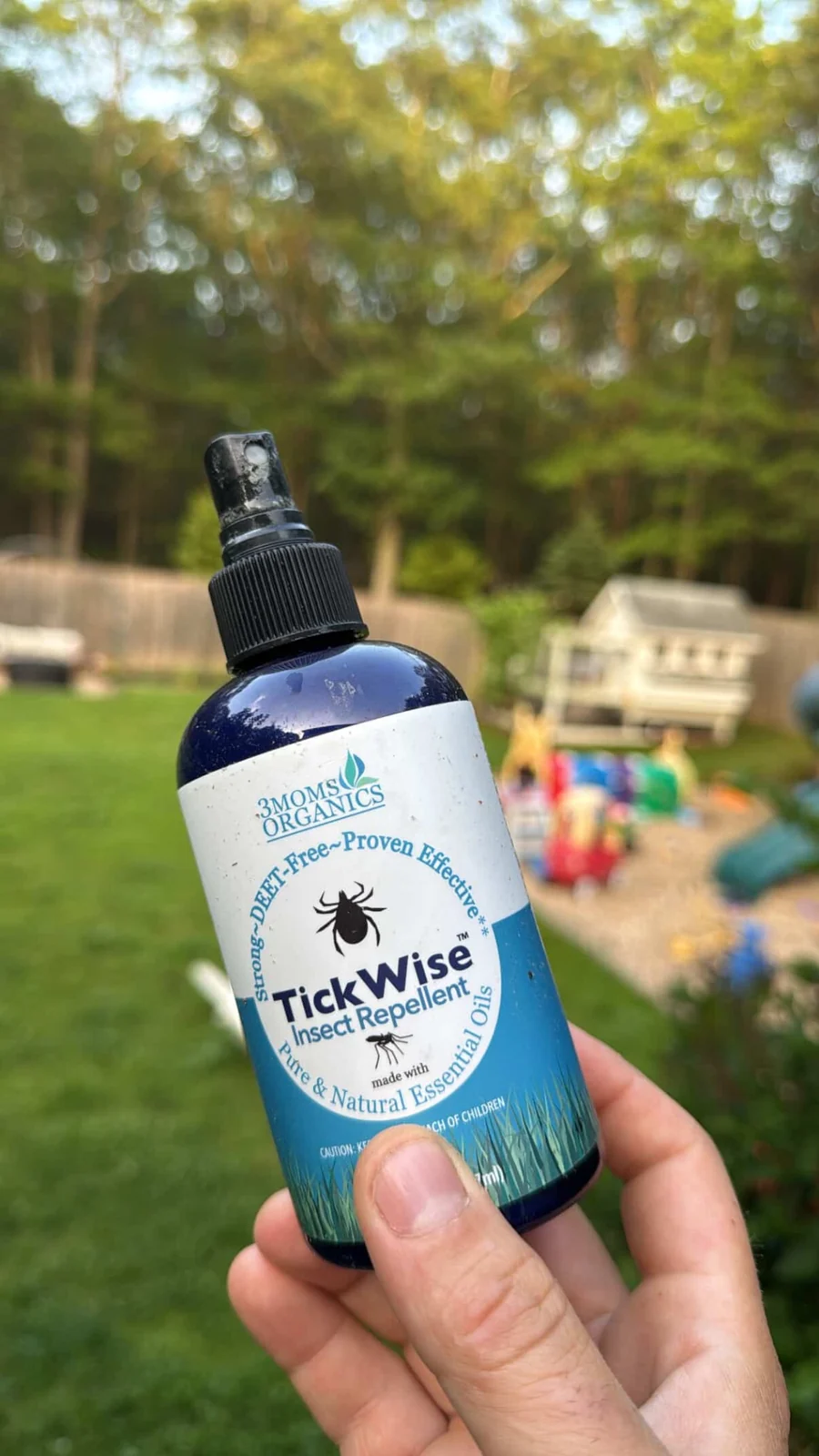 3 Moms Organics TickWise insect repellent being held outside